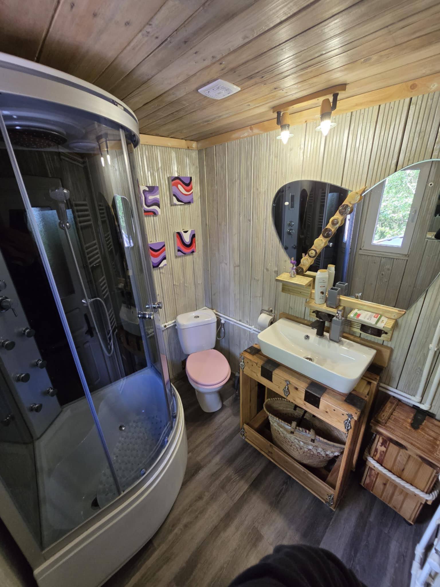 Private bathroom with glass shower, basin and mirror.