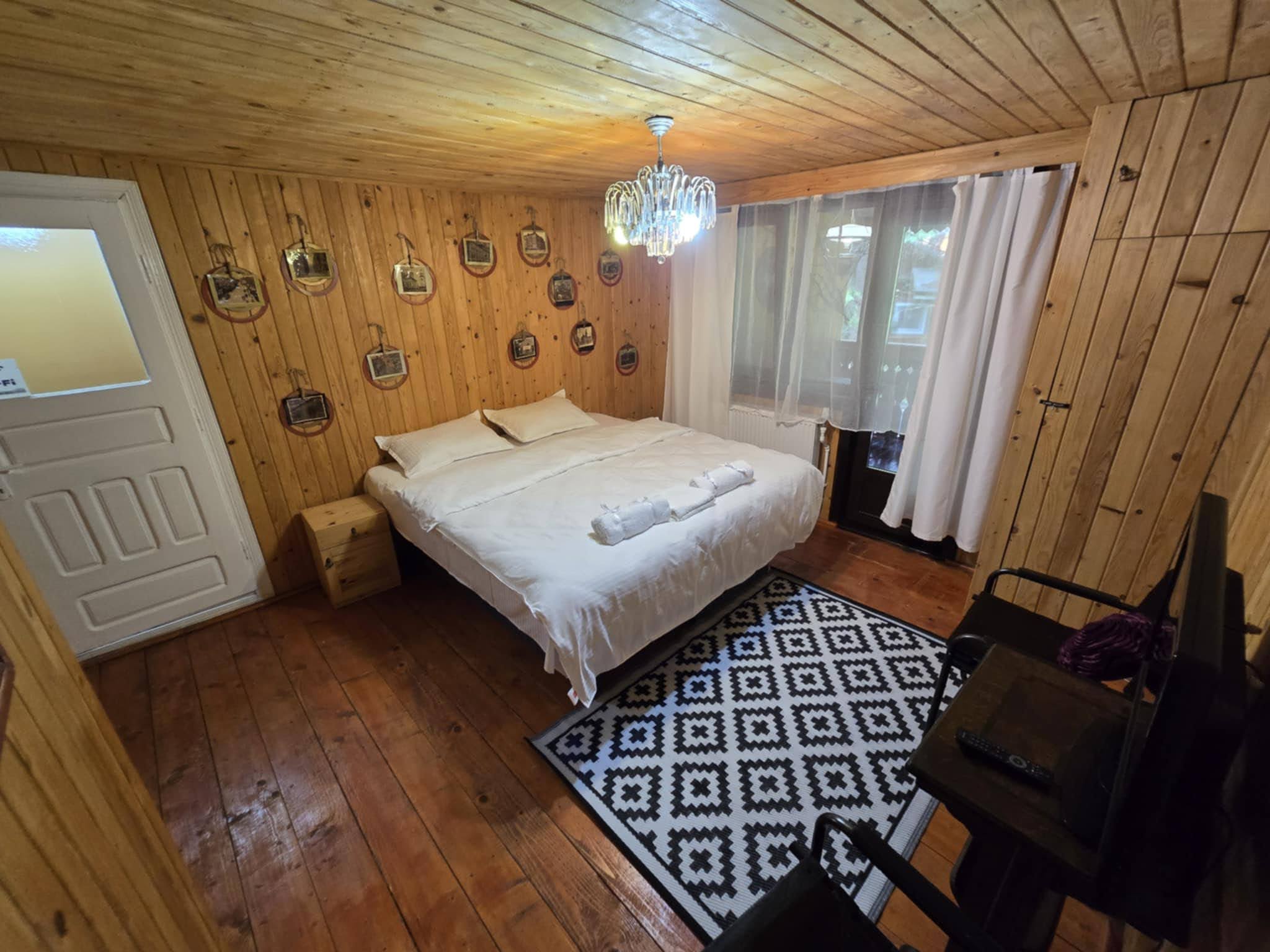 Wood-panelled double bedroom with a patterned rug.