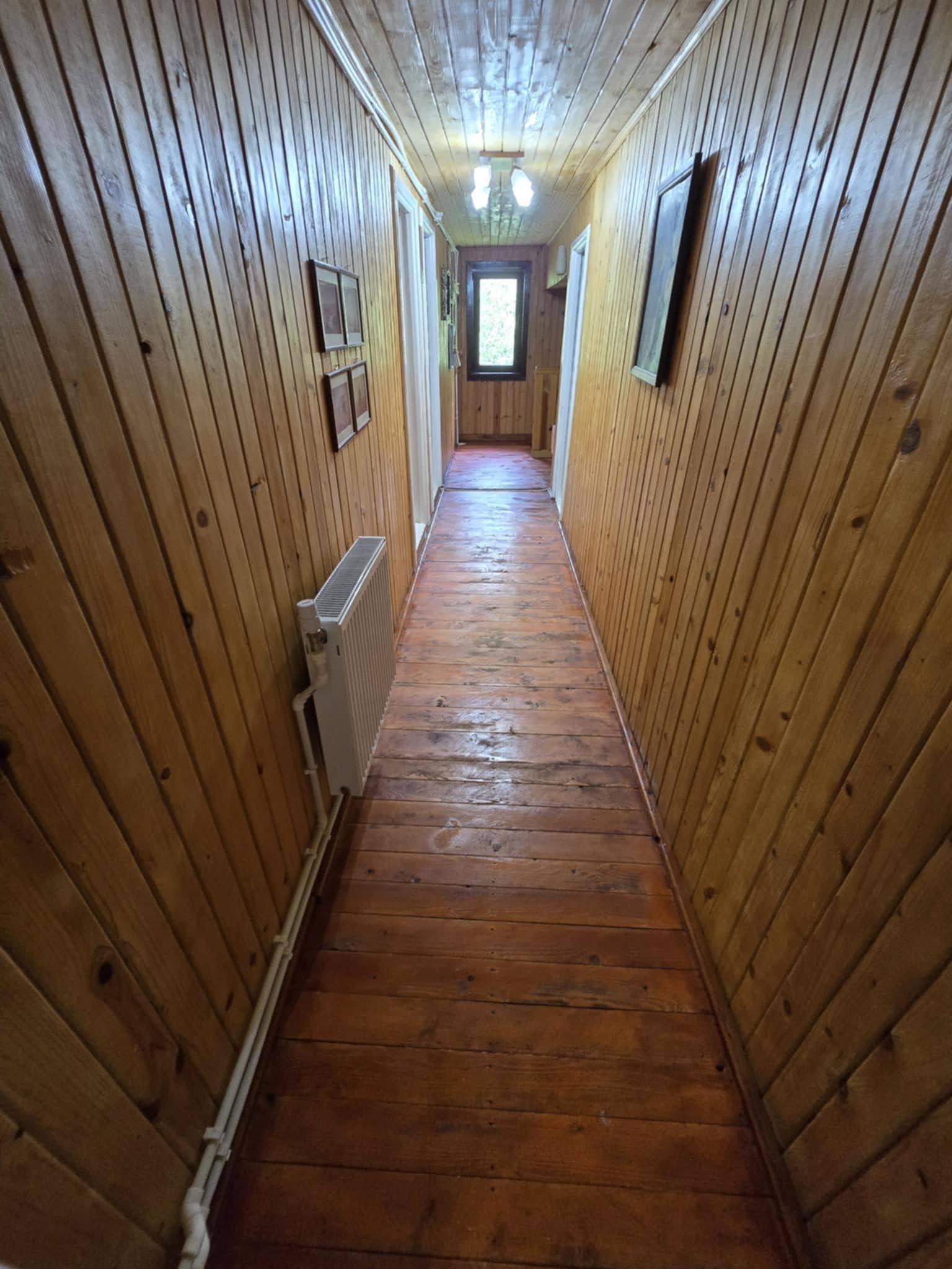 Warm timber-lined hallway leading to the guest rooms.