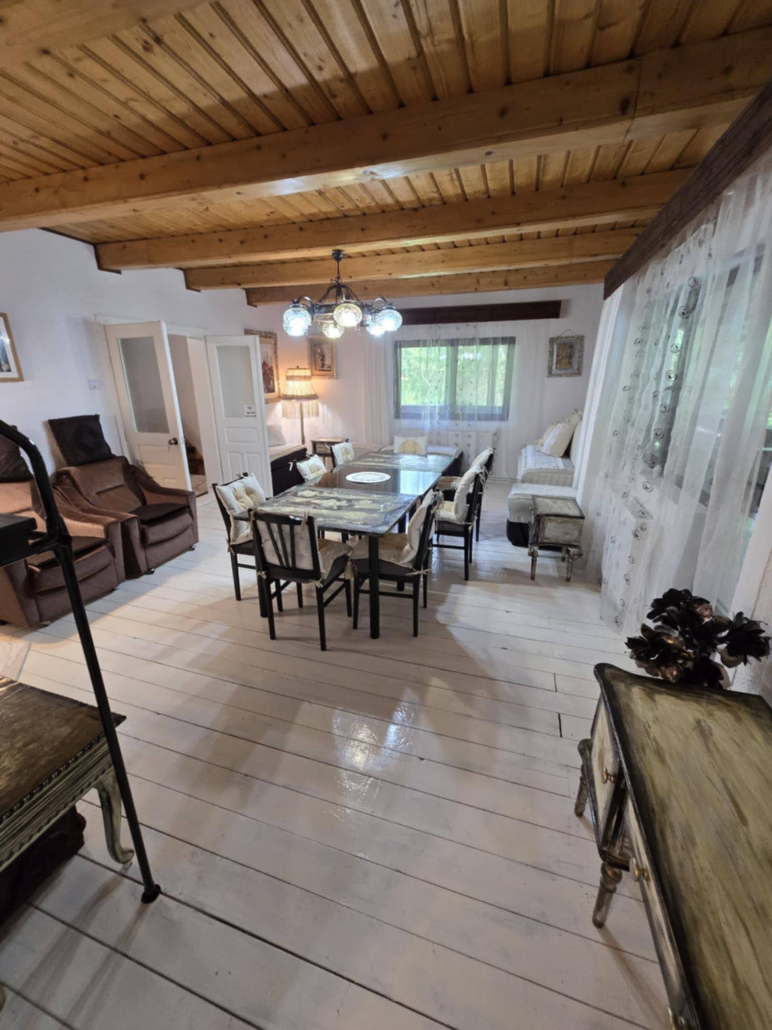 Shared kitchen and living area beneath exposed timber beams.