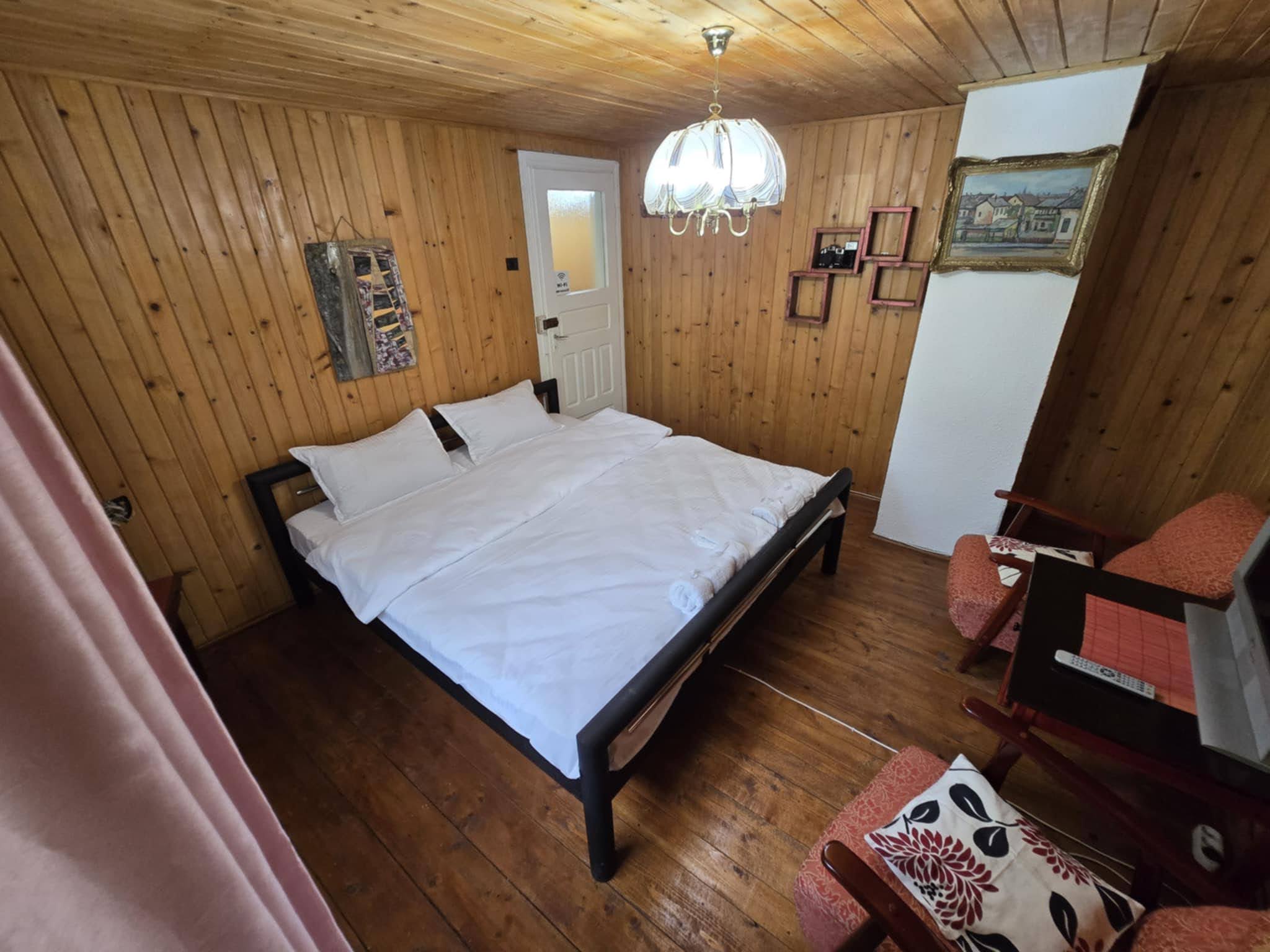 Second wood-panelled bedroom with a double bed.