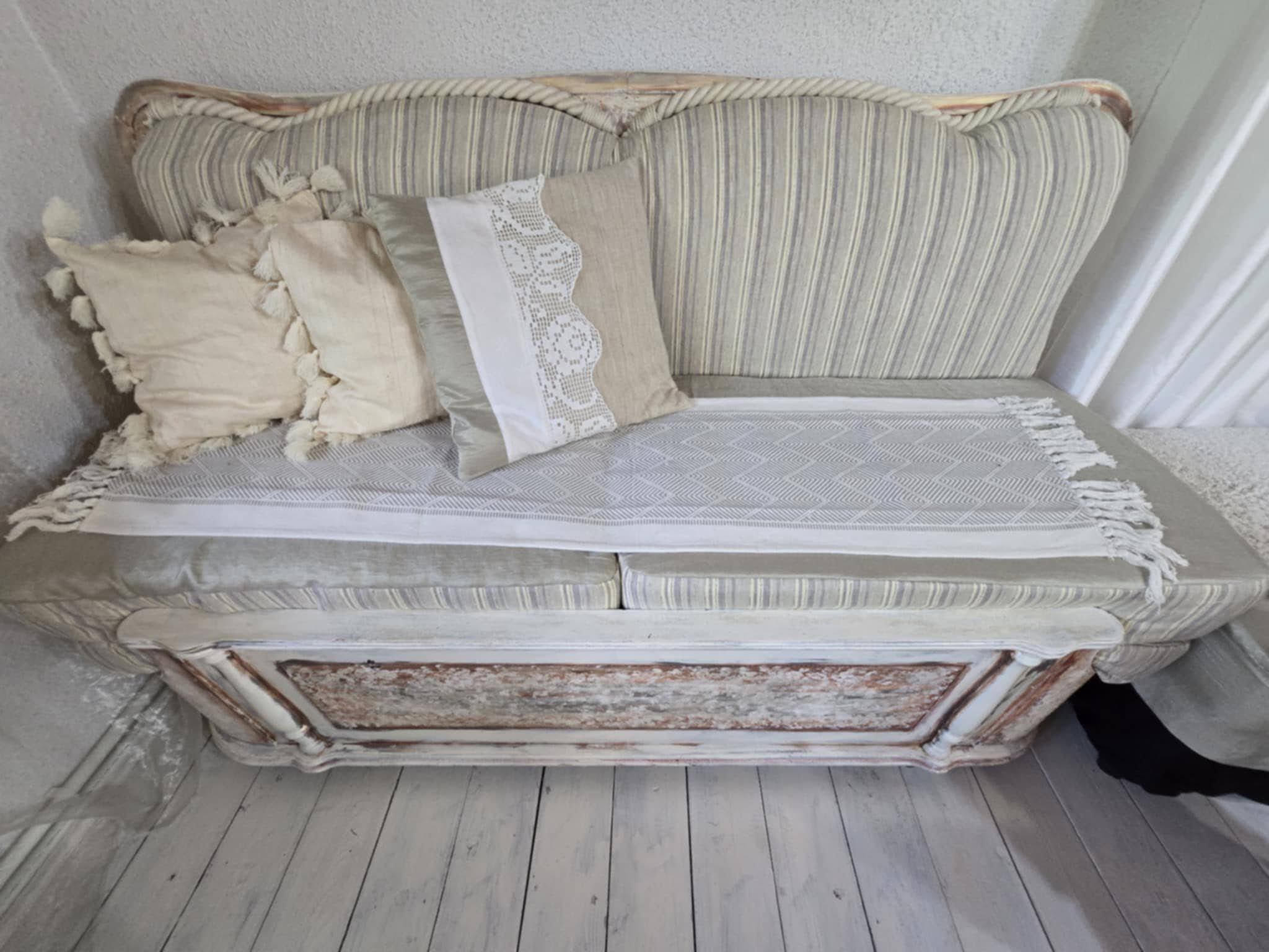Pale upholstered sofa with cushions.