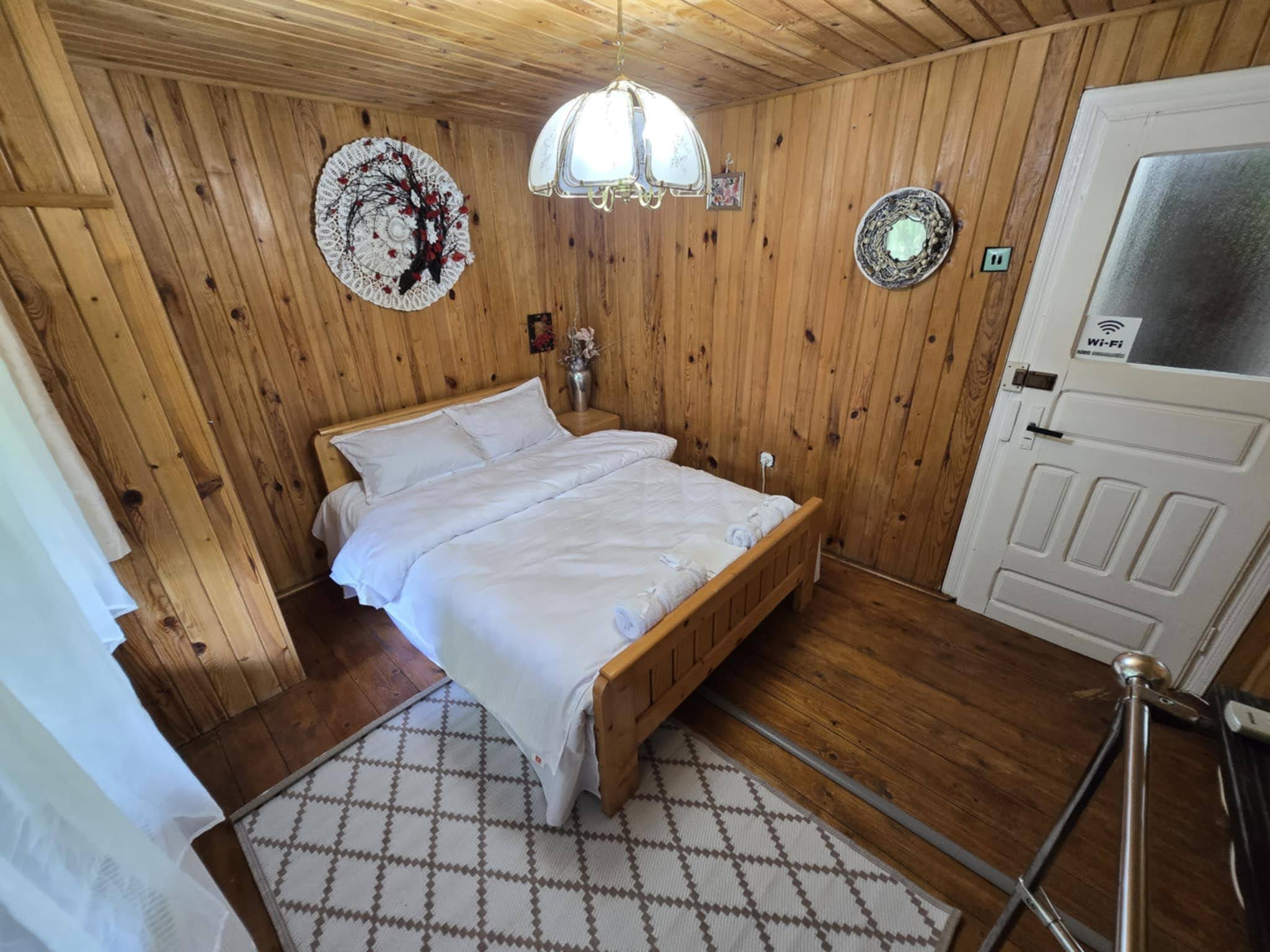 Light double bedroom with white walls and warm wood details.